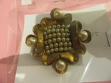 une photo d'une broche ornée de perles