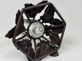 a metal object with leaves and a light inside of it