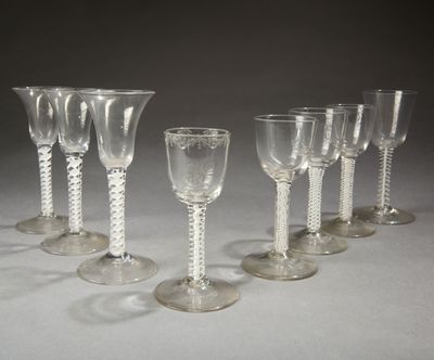 plusieurs verres à vin vides sont alignés sur une surface blanche