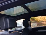 a view of a car ' s sunroof from the passenger seat