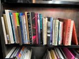 many books that are on a book shelf in the room