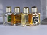 five bottles of perfume sitting on a table next to each other