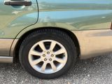 a close up of a car ' s tire on a gravel road