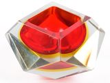 a red and yellow object in a clear glass bowl