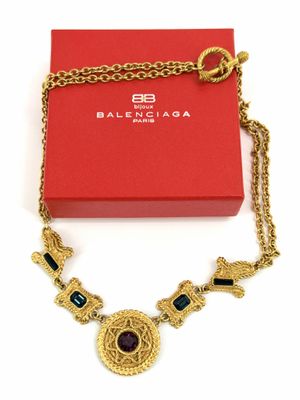 un gros plan d'un collier posé sur une boîte rouge, avec une chaîne