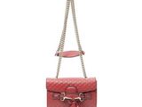 un sac à main rouge avec une bandoulière en chaîne et un pompon