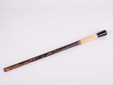 an old wooden stick with a black handle on a white surface