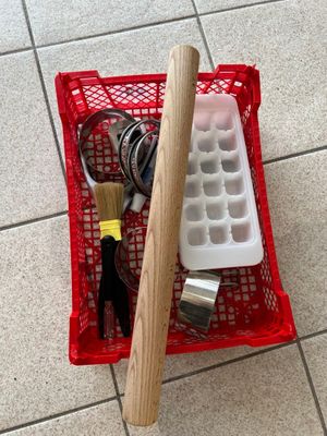 un panier rouge rempli d'outils posé sur un sol carrelé