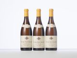 three bottles of wine sitting on top of a white table