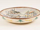 a small bowl with boats on it sitting on a table