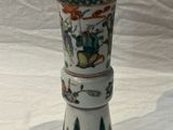 un vase blanc orné d'un motif posé sur une table