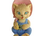 une figurine représentant un chat avec un chapeau rose et une salopette bleue