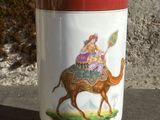 un vase sur lequel est représentée une femme à dos de chameau