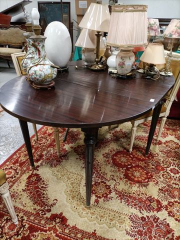 Table ronde à rallonge de style Louis XVI finition acajou verni. 