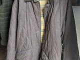 une veste matelassée marron suspendue à un porte-manteau devant une chaise