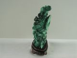 green statue of liberty on a marble base on a white surface