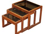 two wooden nesting tables with glass tops on a white background