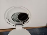 a white toilet with a black lid on the floor