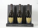 Trois bouteilles de champagne sont exposées dans une boîte noire
