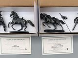 two boxed boxes containing two figurines of horses and a man on a horse