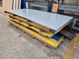 a pile of steel plates on a pallet in a warehouse