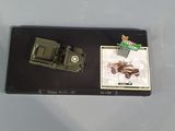 a toy army vehicle and a card on a table