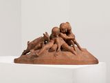 sculpture of a group of people on a rock in a white room