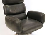une image représentant une chaise de bureau en cuir noir montée sur roulettes, sur fond blanc
