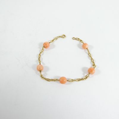 un bracelet en chaîne dorée orné de perles orange sur fond blanc