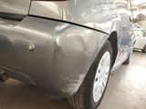 the rear end of a car with a denting dent on it