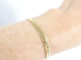 someone is wearing a gold bracelet that has a chain on it