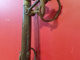 a metal pole with a hook on it in front of a red wall