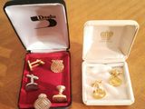 two pairs of cufflinks in a box on a table