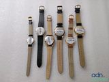 four watches are lined up in a row on a white surface