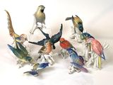 several figurines of birds sitting on top of a white surface