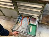 un homme en train d'ouvrir un tiroir contenant des outils