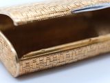 a gold box with a handle on a white surface