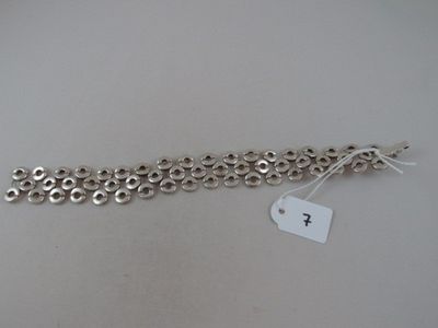 a close up of a silver bracelet with a tag on it
