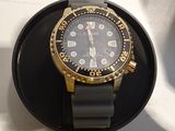 a black and gold watch sitting on a black watch stand