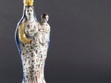 une figurine représentant une femme tenant un bébé et un chat dans ses bras