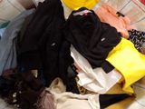 a pile of clothes that is on a bed