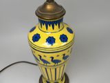 a yellow vase with blue flowers on it on a table