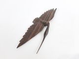 un oiseau en bois posé sur une surface blanche