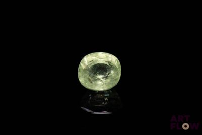 une image représentant une boule de cristal verte posée sur une surface noire