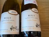 two bottles of wine sitting on a shelf next to each other