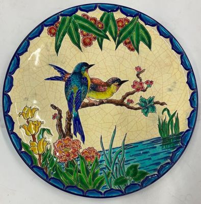 une assiette avec un oiseau et des fleurs