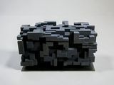 a black object made out of lego blocks on a white surface