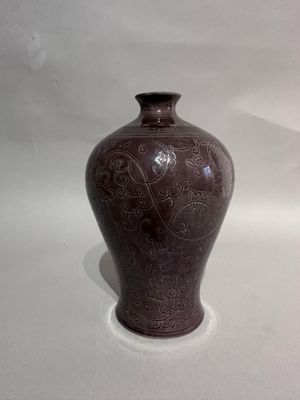 a brown vase that is sitting on a white surface