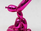 pink balloon dog sculpture sitting on top of a white surface