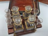bottles and glasses in a wooden case on a white surface